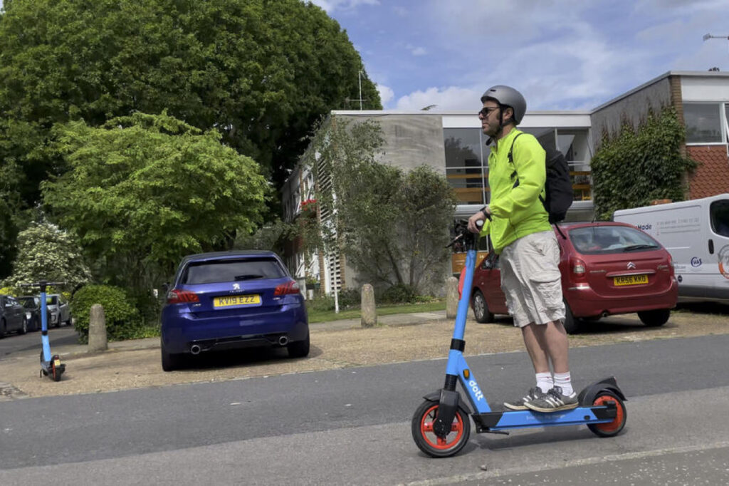 Man riding blue eScooter on a residential in the UK 