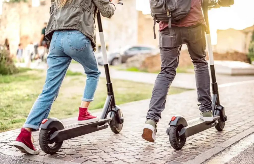 two people on eScooters traveling on the road together